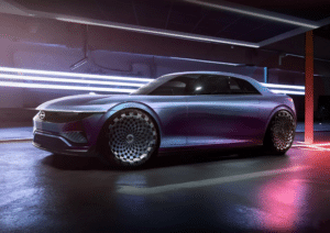 Concepto de un Nissan Silvia eléctrico para el año 2025, mostrando un vehículo de perfil bajo y aerodinámico con una carrocería elegante en tonos degradados de púrpura a plata. Destacan sus ruedas futuristas con un diseño intrincado, faros delanteros LED en forma de línea horizontal y la distintiva parrilla frontal cerrada que sugiere su naturaleza eléctrica. El coche está estacionado en un ambiente oscuro e iluminado por luces neón que acentúan su modernidad y diseño avanzado.